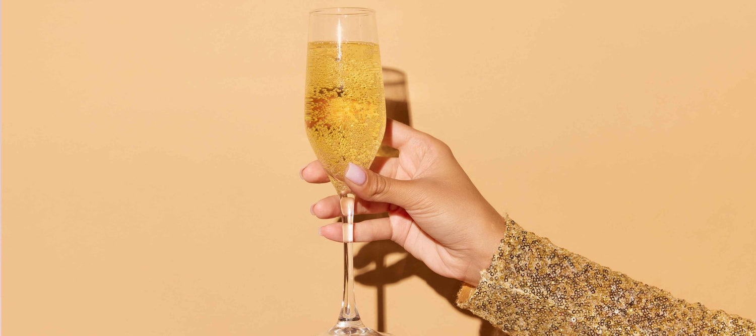 Champagneglazen op een rij: flute, coupe en tulpglas gevuld met bubbels